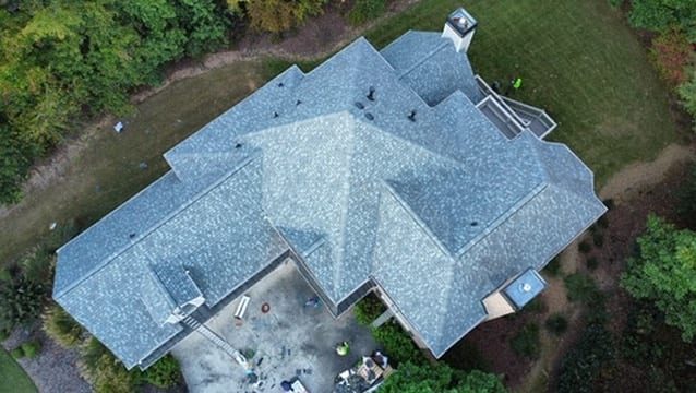 Aerial view of a light gray shingle roof on a sprawling home